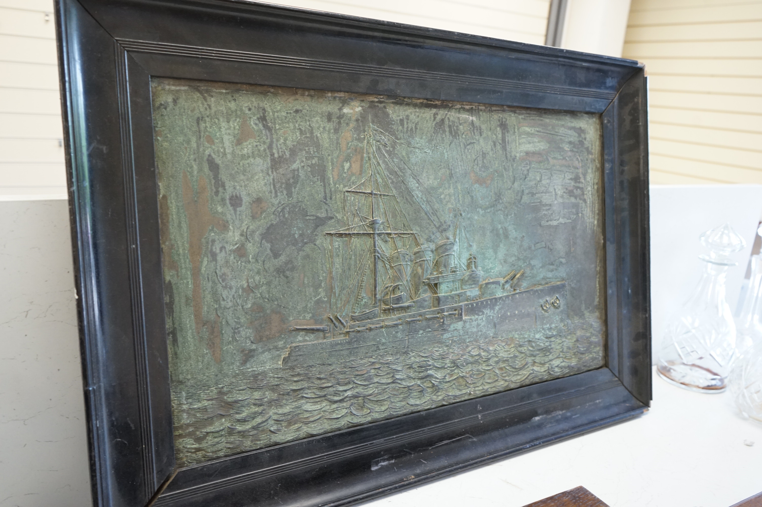 A metal relief panel of a ship, framed, 53cm high